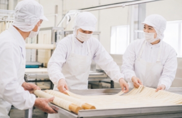 手作業で素麺の生地を加工するスタッフ