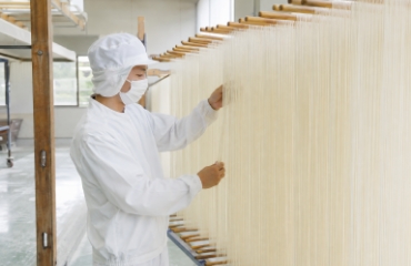 干された素麺の状態を確認するスタッフ